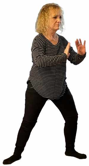 Woman standing on floor in Qi Gong pose.